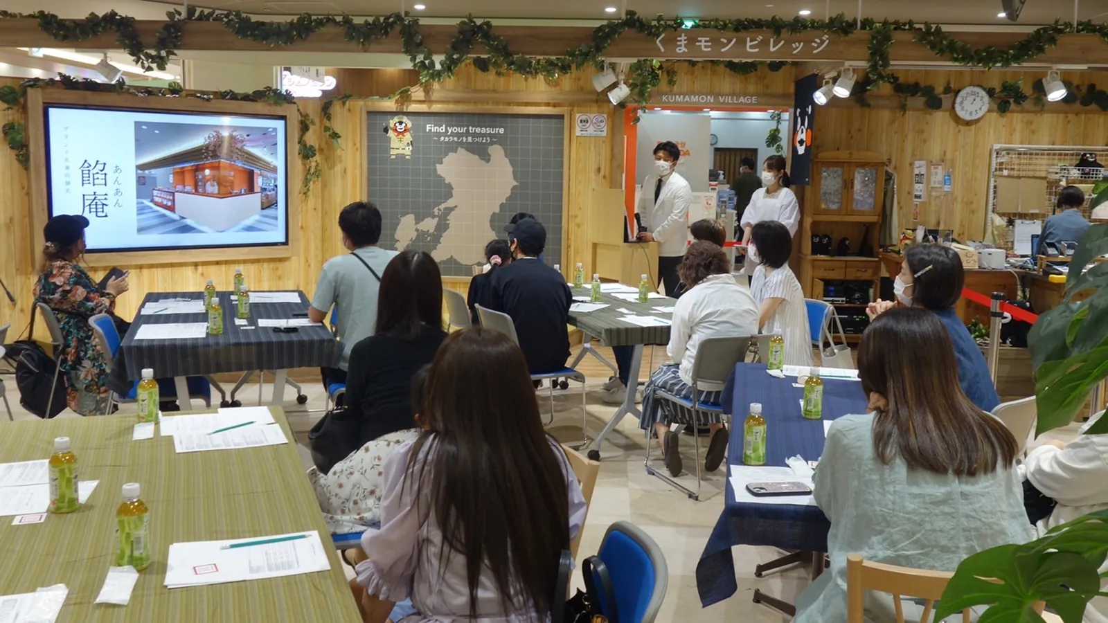 第一回試食会の会場。スクリーンに「餡庵」の店舗イメージを映し、参加者の皆さまが席についている様子